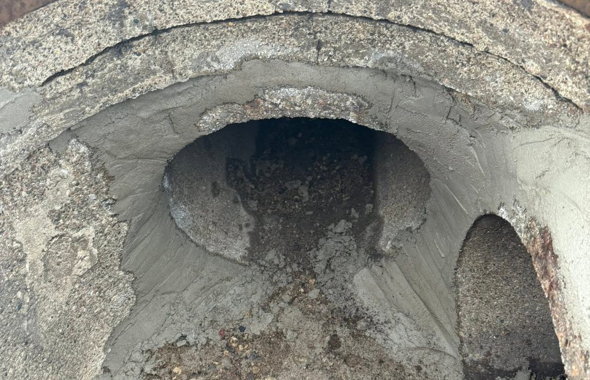 Inside a failed catch basin, the collar rusted and the mortar washed out