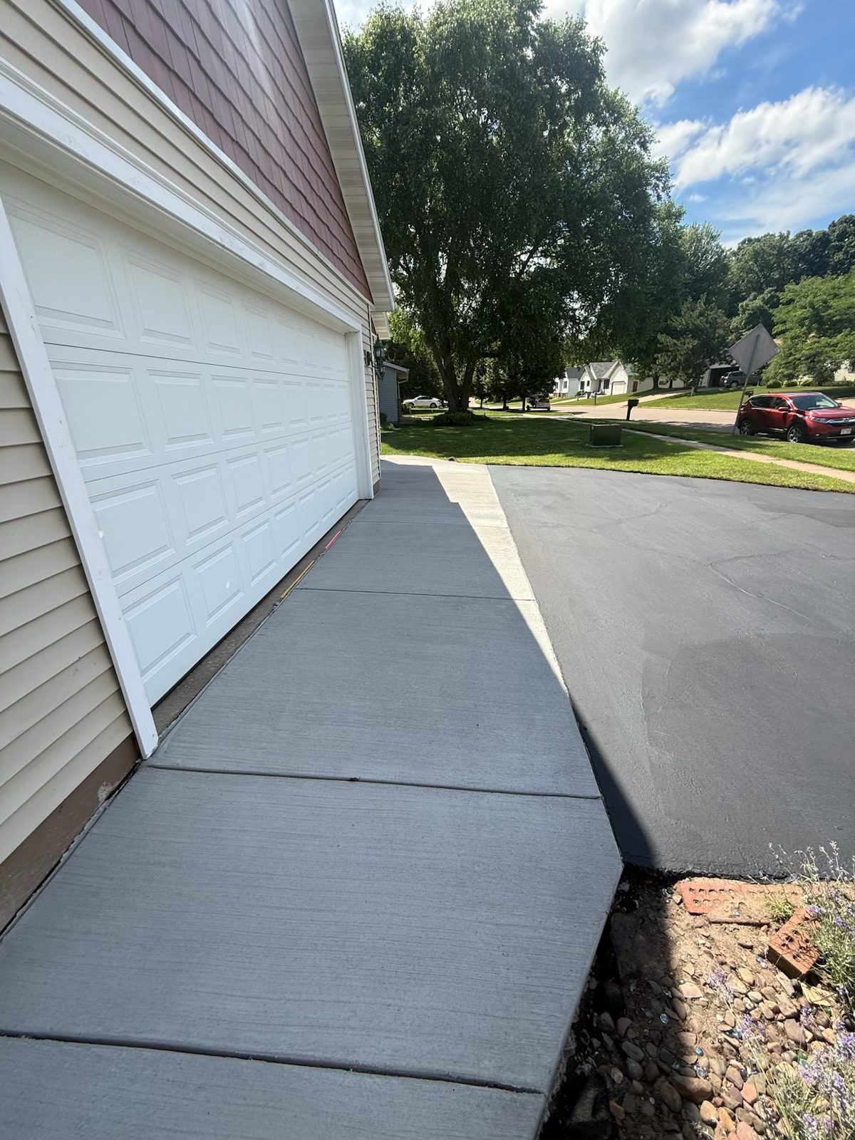 A new concrete apron and jointed walk poured up to a garage door on a residential drive