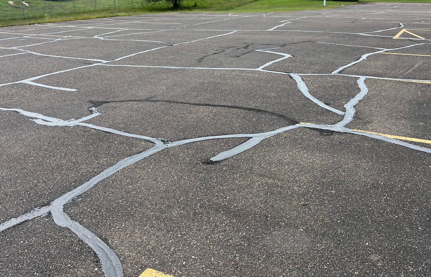 A web of freshly filled cracks running across a parking lot